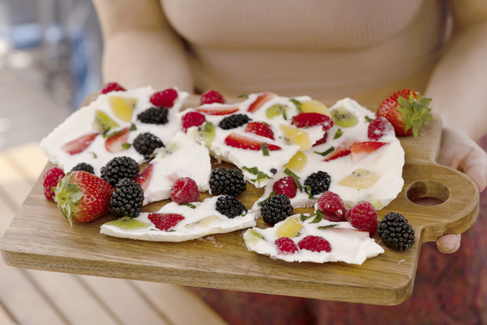Foto: Sarah Wiener Stiftung Eis-Joghurt mit verschiedenem Obst auf einem Holzbrett