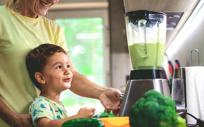 Foto: Kristyna Davidova/Gettyimages Kind mit Mutter in der Küche an einem Standmixer.